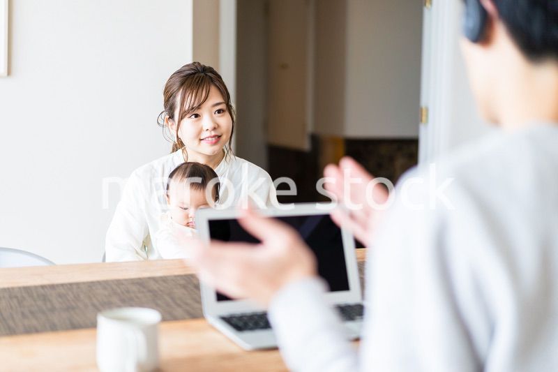 在宅勤務をするお父さんと子育てをするお母さん
