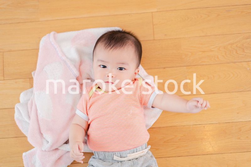 おうちの床に寝転がる赤ちゃん