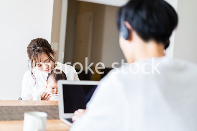 在宅勤務をするお父さんと子育てをするお母さん