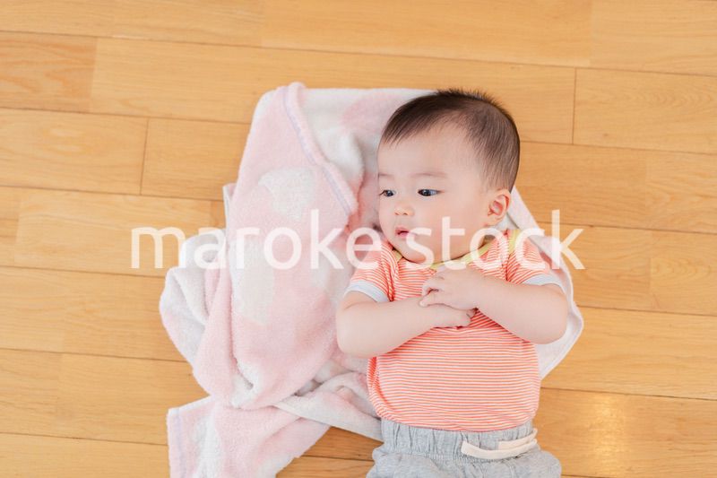 おうちの床に寝転がる赤ちゃん