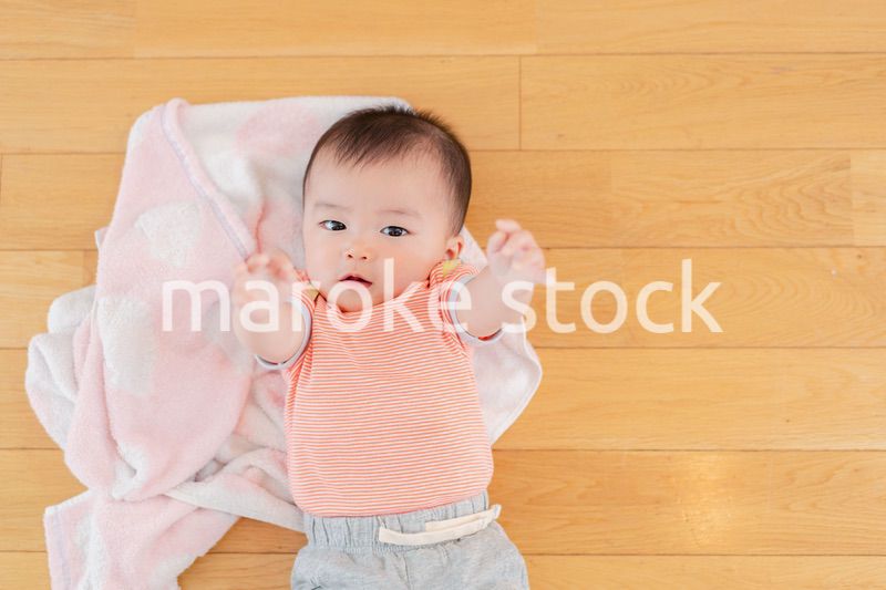 おうちの床に寝転がる赤ちゃん