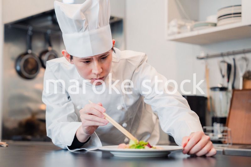 料理の盛り付けをする男性シェフ