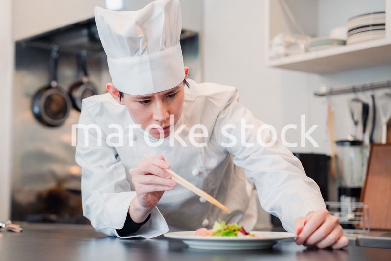 料理の盛り付けをする男性シェフ