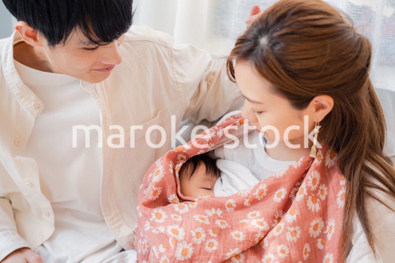 赤ちゃんに授乳をする母親とお父さん