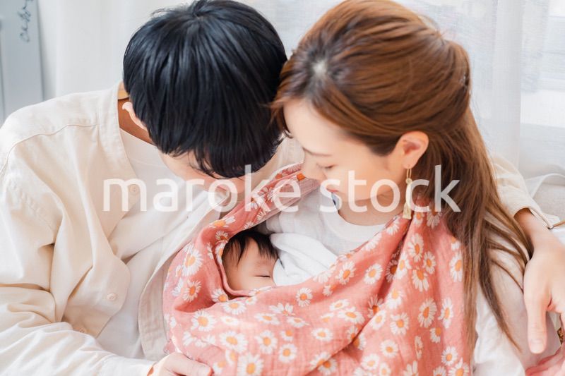 赤ちゃんに授乳をする母親とお父さん