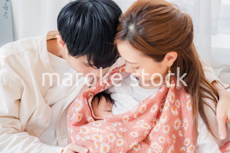 赤ちゃんに授乳をする母親とお父さん