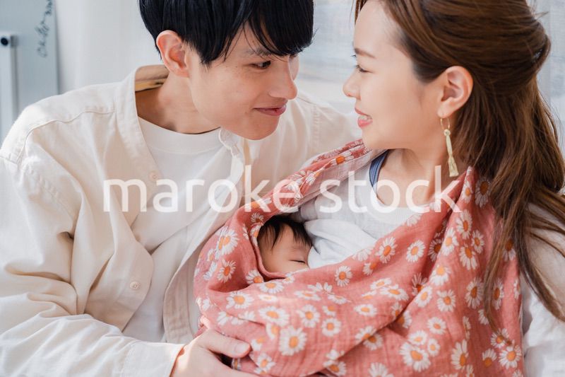 赤ちゃんに授乳をする母親とお父さん