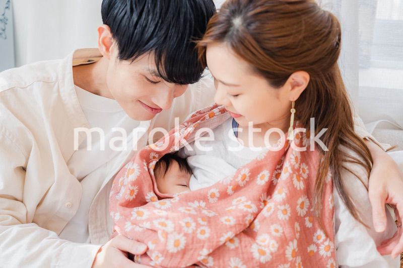 赤ちゃんに授乳をする母親とお父さん