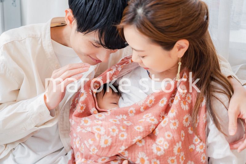 赤ちゃんに授乳をする母親とお父さん