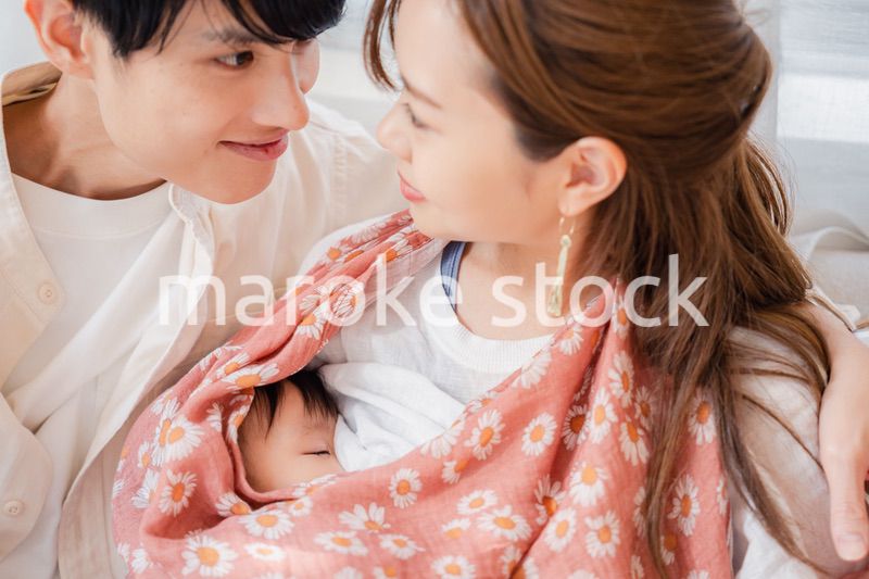 赤ちゃんに授乳をする母親とお父さん