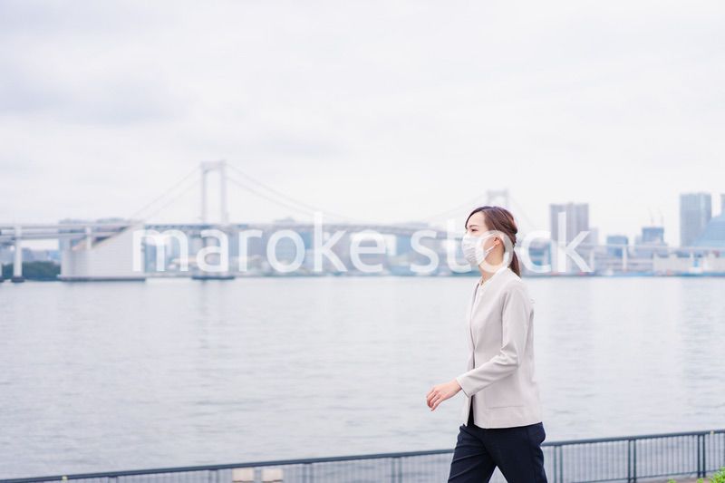 マスクをして都会を歩くビジネスウーマン