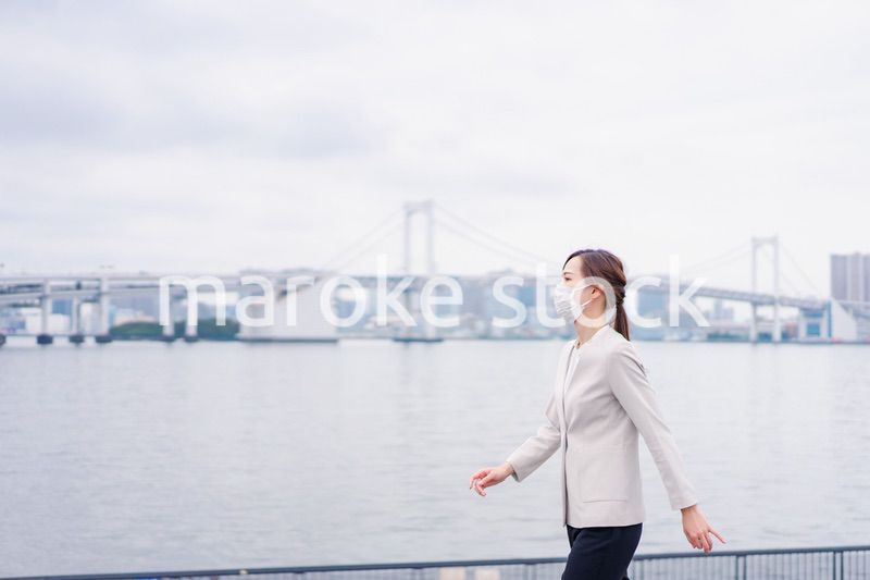 マスクをして都会を歩くビジネスウーマン