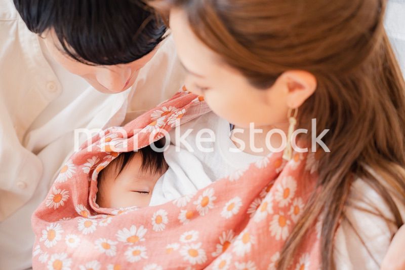 赤ちゃんに授乳をする母親とお父さん