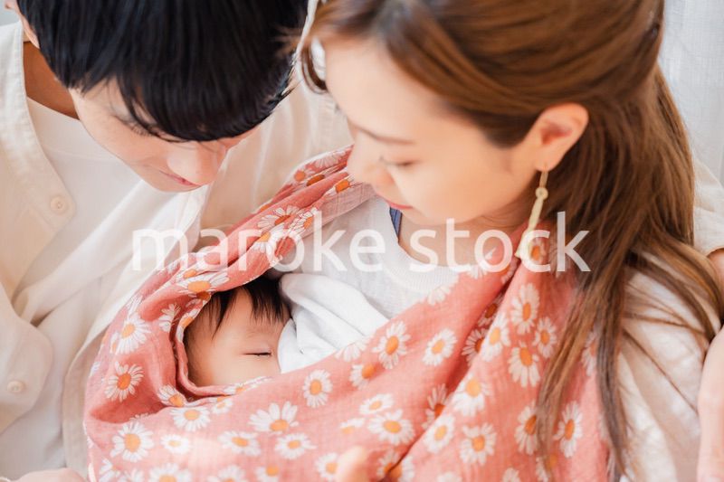 赤ちゃんに授乳をする母親とお父さん