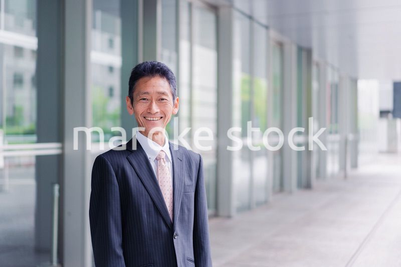 ビルの前に立つ経営者