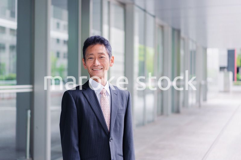 ビルの前に立つ経営者
