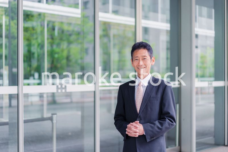 ビルの前に立つ経営者