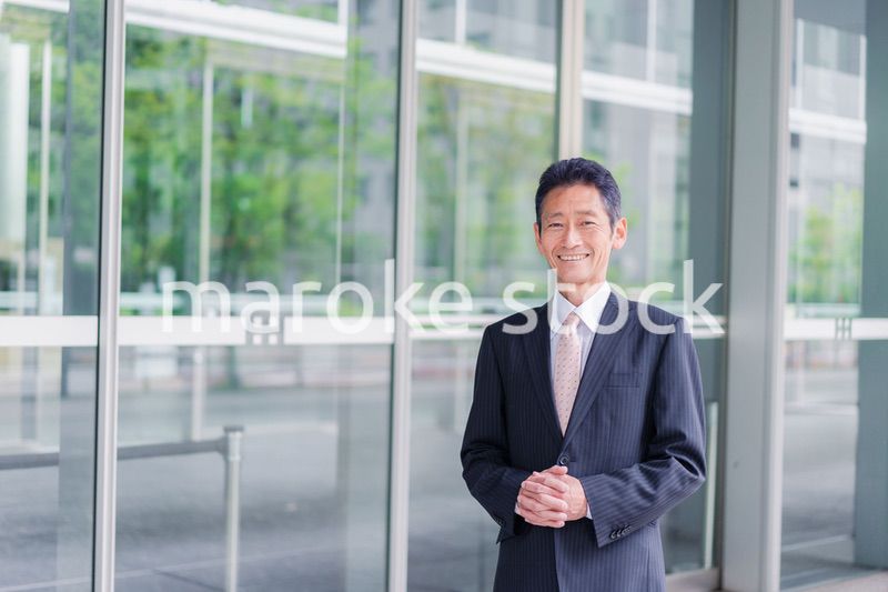 ビルの前に立つ経営者