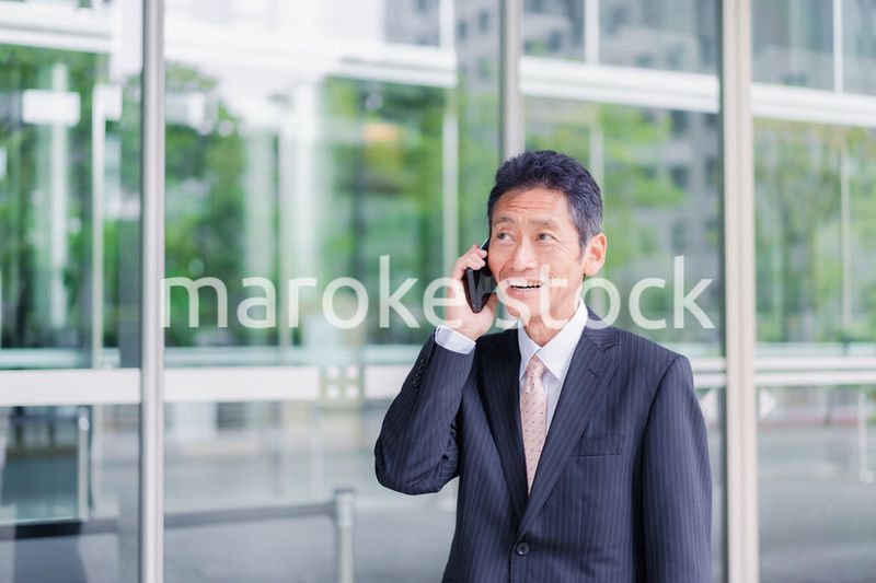 オフィス街で電話をするサラリーマンの男性