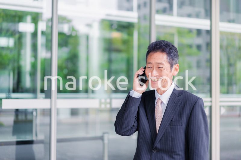 オフィス街で電話をするサラリーマンの男性
