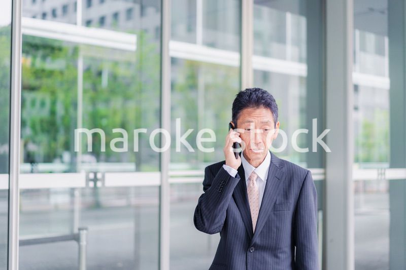 オフィス街で電話をするサラリーマンの男性