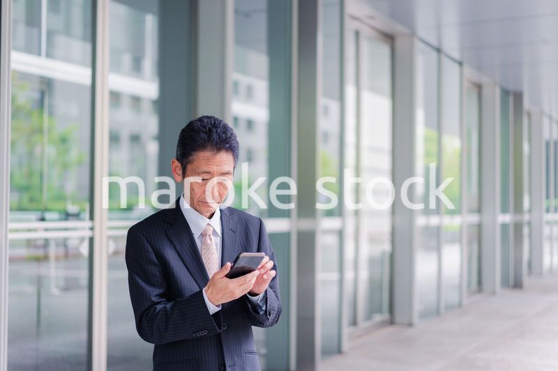 スマホアプリを使う中年のビジネスマン