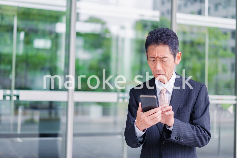 スマホアプリを使う中年のビジネスマン