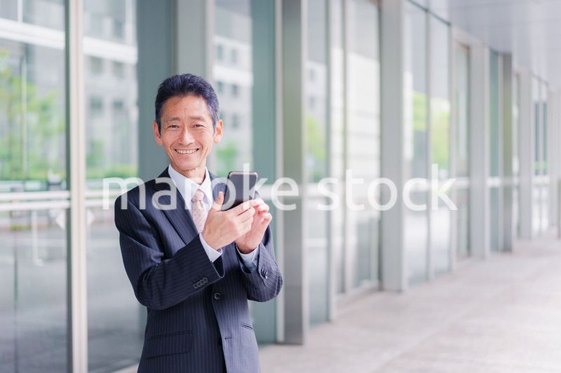 スマホアプリを使う中年のビジネスマン