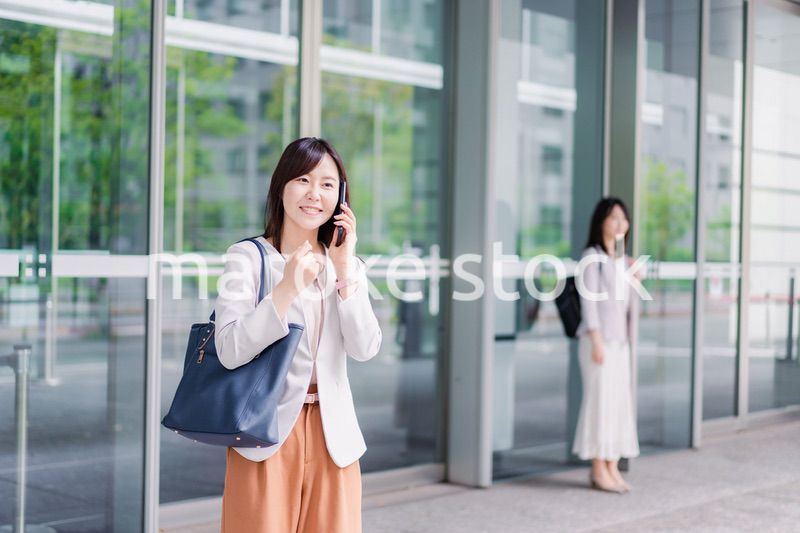 電話でタクシーを呼ぶ若いビジネスウーマン