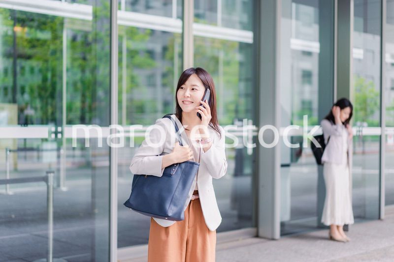 電話でタクシーを呼ぶ若いビジネスウーマン