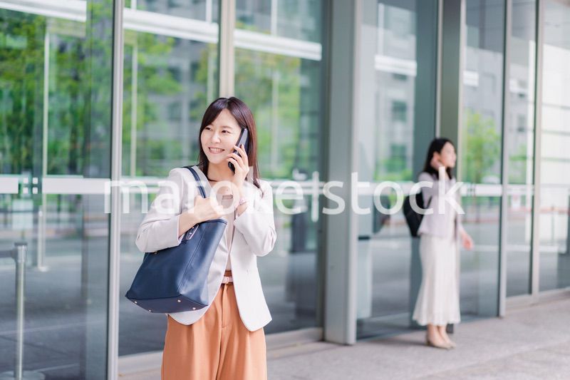 電話でタクシーを呼ぶ若いビジネスウーマン