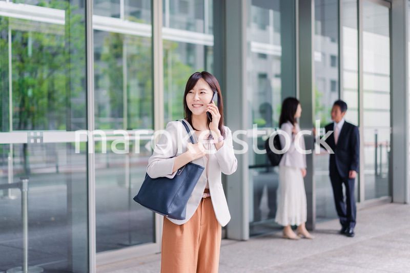 笑顔でスマホを使うビジネスウーマン