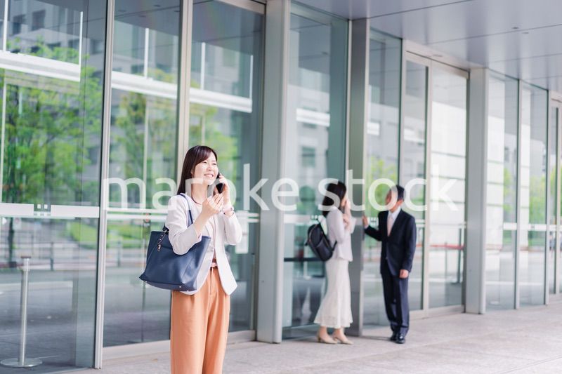 笑顔でスマホを使うビジネスウーマン