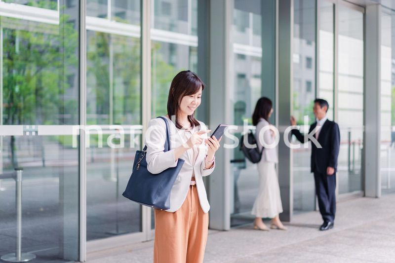 笑顔でスマホを使うビジネスウーマン