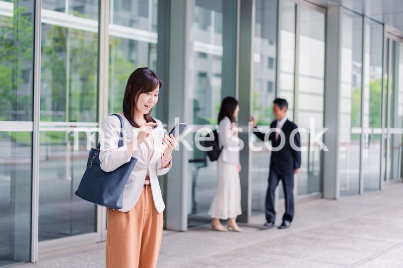 笑顔でスマホを使うビジネスウーマン