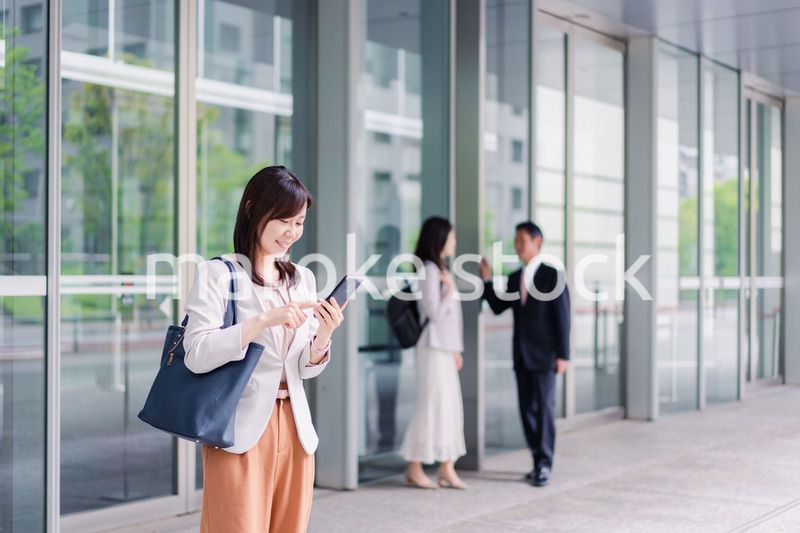 笑顔でスマホを使うビジネスウーマン