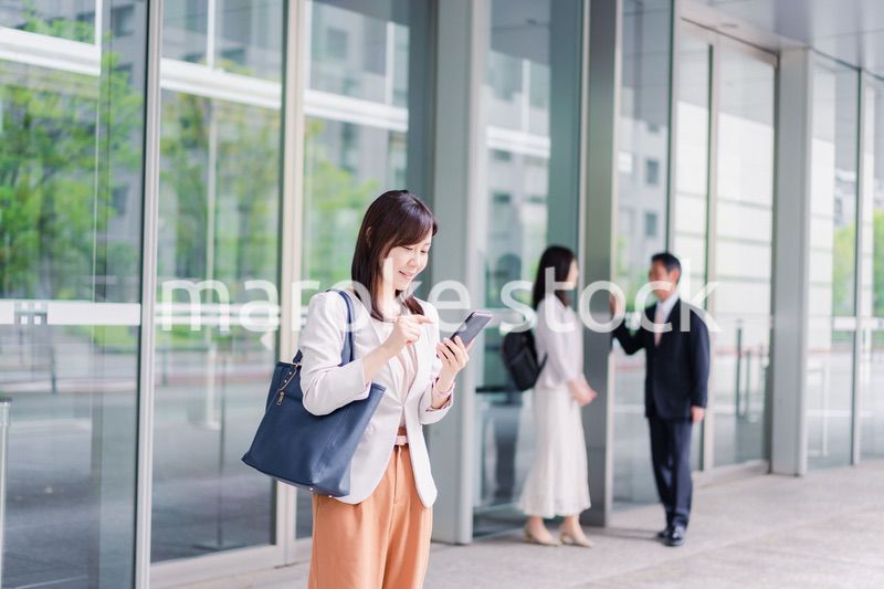 笑顔でスマホを使うビジネスウーマン