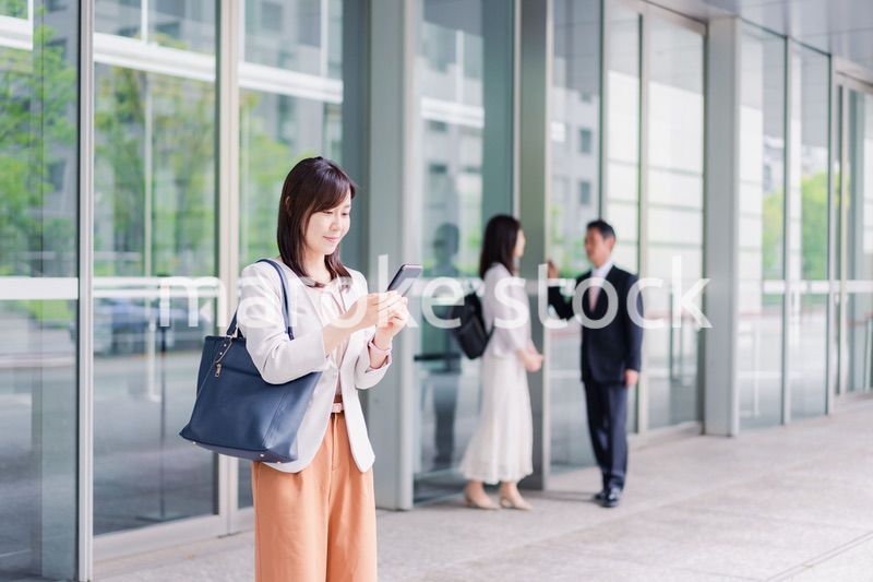 笑顔でスマホを使うビジネスウーマン