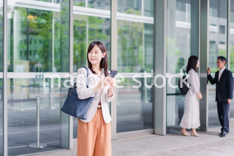 笑顔でスマホを使うビジネスウーマン