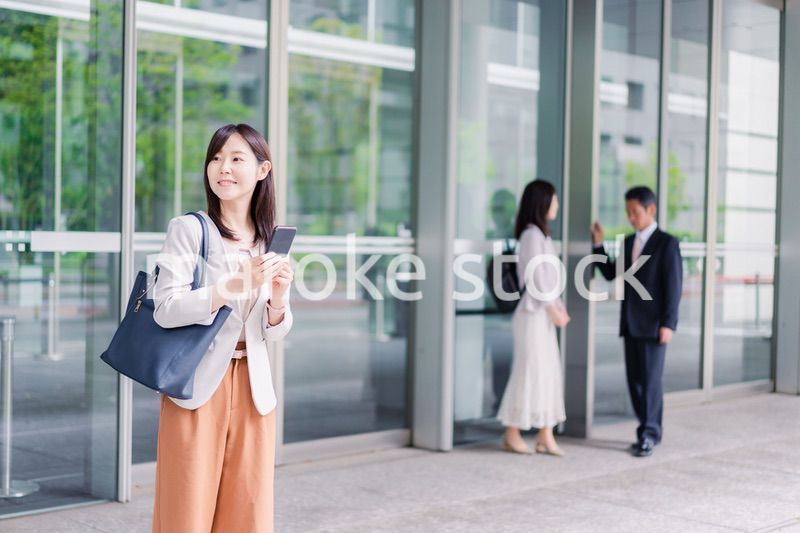 笑顔でスマホを使うビジネスウーマン