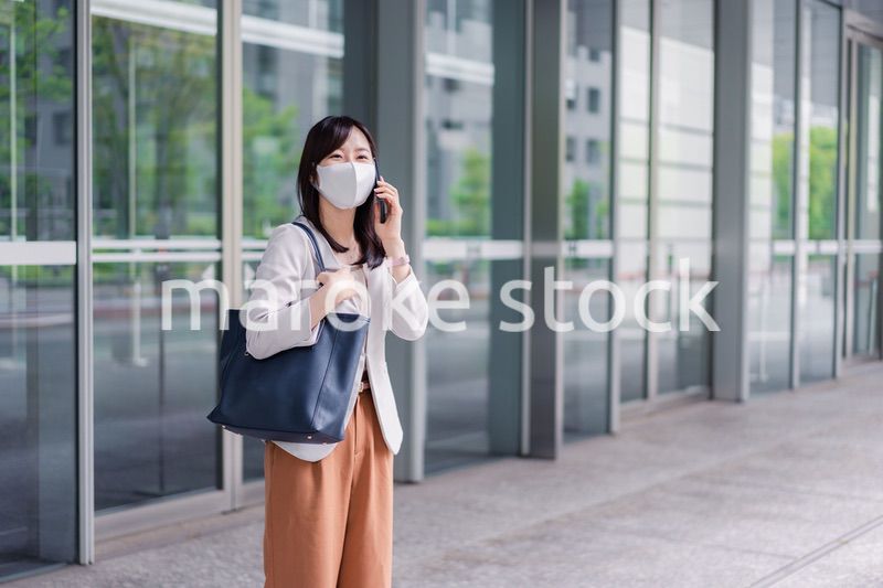 マスクをしてスマホを使う若い女性