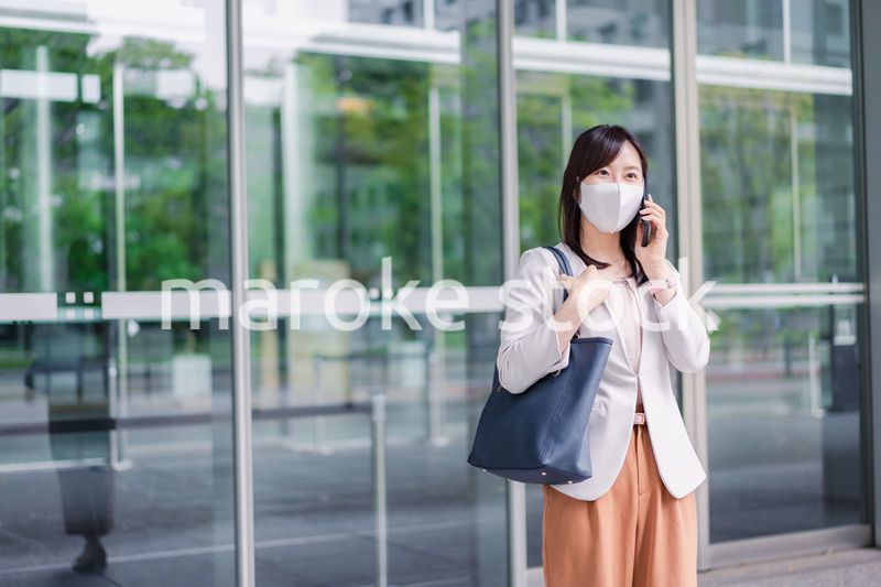 マスクをしてスマホを使う若い女性