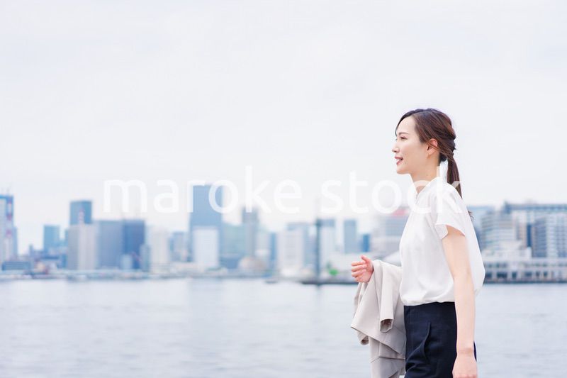 ジャケットを脱いで外を歩くビジネスウーマン