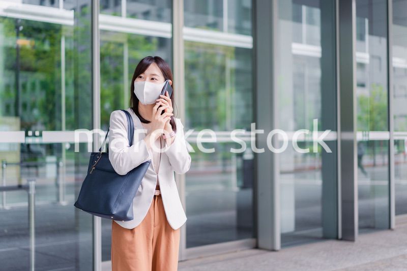 マスクをしてスマホを使う若い女性