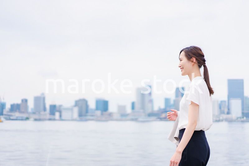 ジャケットを脱いで外を歩くビジネスウーマン