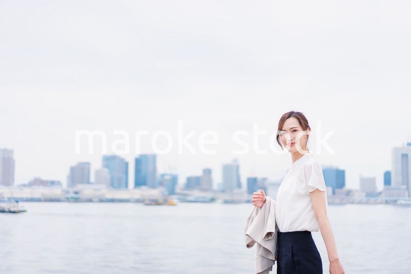 ジャケットを脱いで外を歩くビジネスウーマン