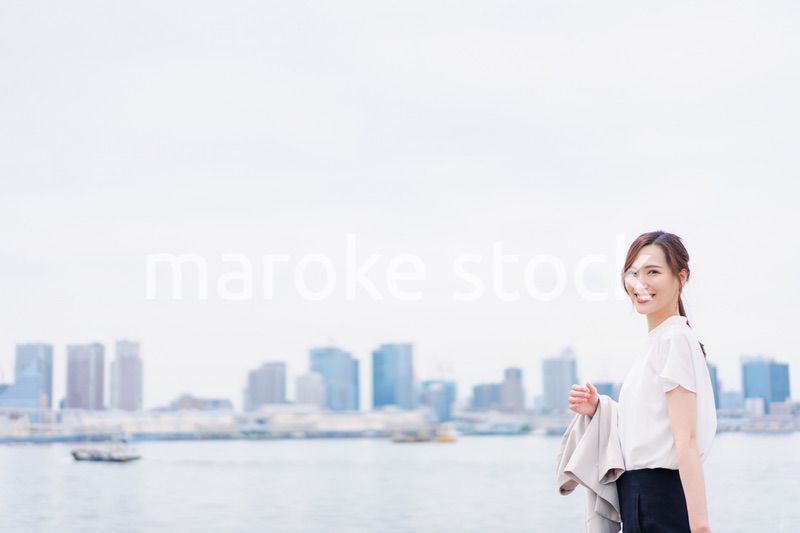 ジャケットを脱いで外を歩くビジネスウーマン