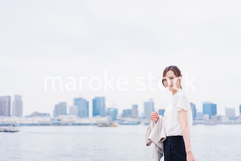 ジャケットを脱いで外を歩くビジネスウーマン