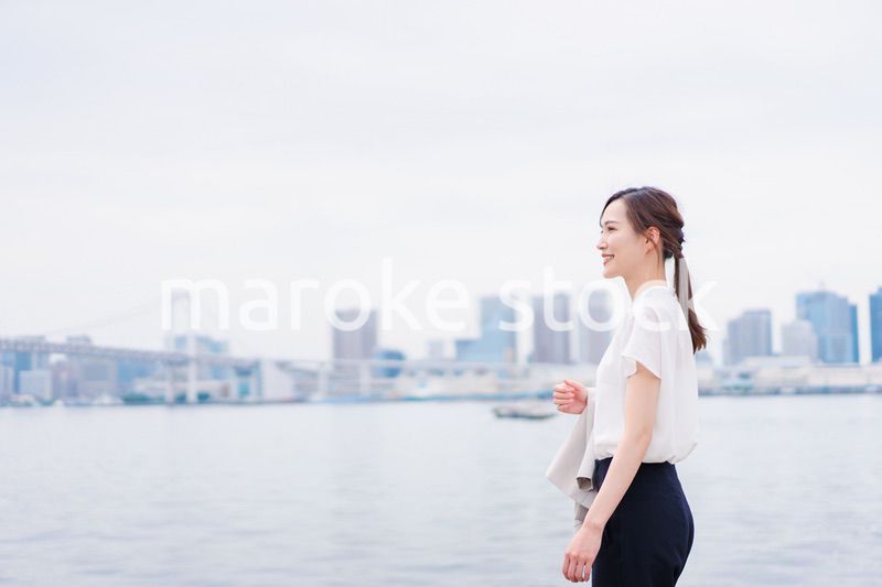 ジャケットを脱いで外を歩くビジネスウーマン