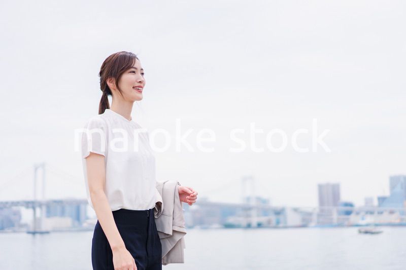 ジャケットを脱いで外を歩くビジネスウーマン